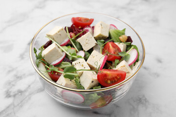 Bowl of tasty salad with tofu and vegetables on white marble table, closeup