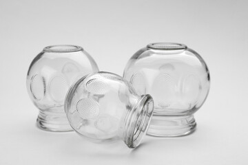 Glass cups on light grey background, closeup. Cupping therapy