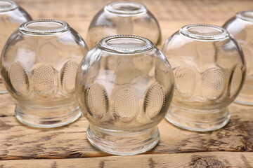 Glass cups on wooden table, closeup. Cupping therapy