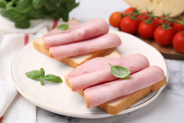 Delicious sandwiches with ham on white table, closeup