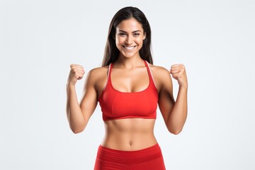 Portrait of a smiling sportswoman in red sportswear showing her biceps isolated on a white background and Looking at the camera.