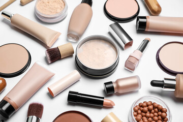 Face powders and other makeup products on white background, closeup