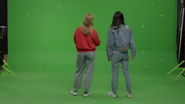 GREEN SCREEN CHROMA KEY Two females student pretending she is visiting art exhibition 