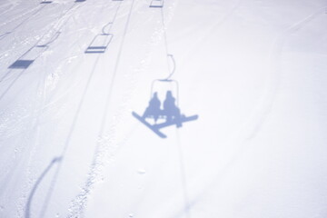 雪に写るリフトに乗るカップルの影