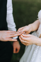 The bride puts a gold ring on her finger at the ceremony. Wedding photography of the newlyweds, close-up portrait.