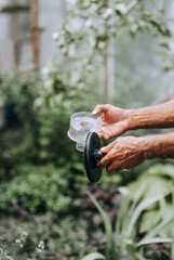 Adult male worker professional holds a clean air filter in his hands outdoors. Photography, close-up portrait.