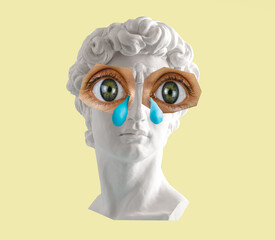 White plaster statue head of David with big eyes and tears on yellow background. Minimal art poster.