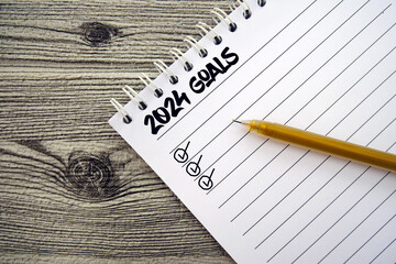 New year resolutions 2024. 2024 goals list with notebook on wooden background. Resolutions, plan,...