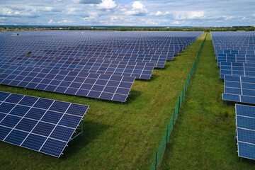 Aerial view of large sustainable electrical power plant with rows of solar photovoltaic panels for...