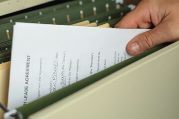 File cabinet searching for files, hand close up on fail folders, copy space background image