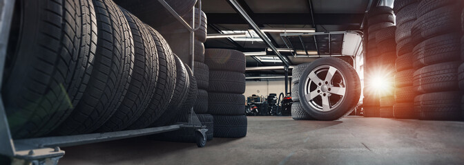 tire at repairing service garage background. Technician man replacing winter and summer tyre for safety road trip. Transportation and automotive maintenance concept - obrazy, fototapety, plakaty