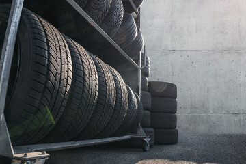 tire in warehouse at repairing service garage background. Technician man replacing winter and...