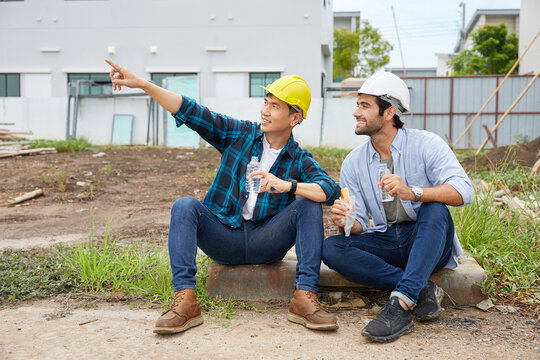 Workers Or Architect Taking A Break And Looking At The Construction Site