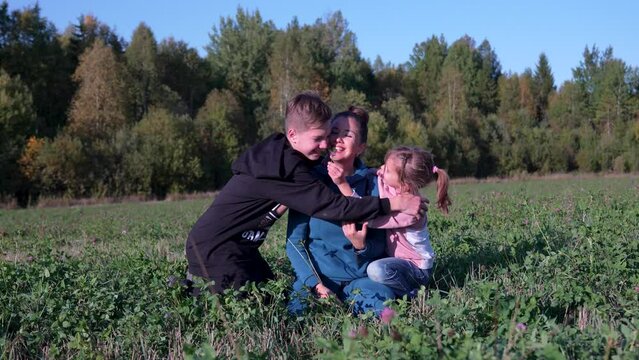 Mother, son and daughter in a happy embrace, outdoors