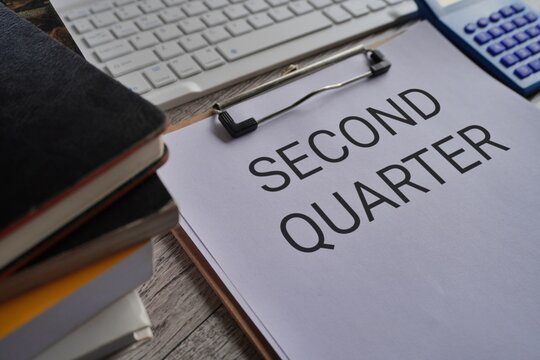 Close up image of paper clipboard with text SECOND QUARTER on office desk