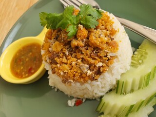 Crab egg rice with seafood dipping sauce on a wooden table, Thailand