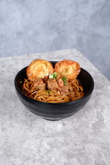 noodles topped with fried egg, green onions, fried shallots