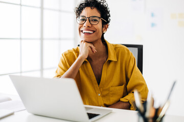 Professional business woman smiling at the camera. Woman sitting at her office desk