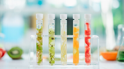 Close up of tissue of avocado, cucumber, kiwi, orange and tomato in test tube. Cosmetic laboratory. Experiment of vitamin in serum, skin care, lotion, treatment, essence and medical body product.