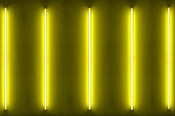 Five yellow neon bulbs on white wall with glowing yellow neon lights. texture background.