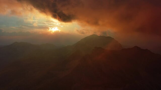 Aerial view of spectacular sunset with mountains and dramatic clouds, 4k