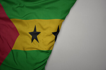 big waving national colorful flag of sao tome and principe on the gray background.