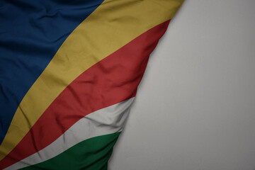 big waving national colorful flag of seychelles on the gray background.
