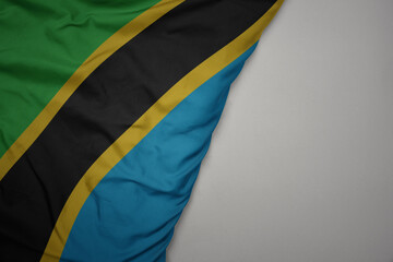 big waving national colorful flag of tanzania on the gray background.