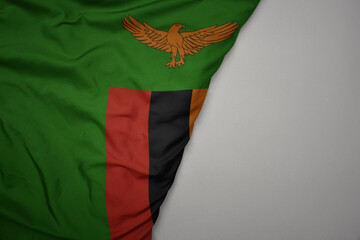 big waving national colorful flag of zambia on the gray background.