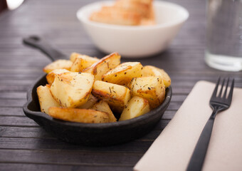 Golden fried potatoes on small cast iron skillet