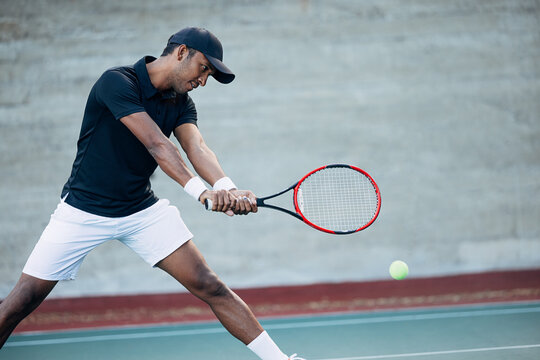 Tennis player receiving the serve. Professional tennis player hitting a ball with a racket.