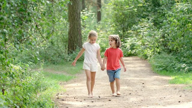 boy and girl walking barefoot in the forest, hardening children, improving children's immunity, playing in nature, children's foot massage technique 