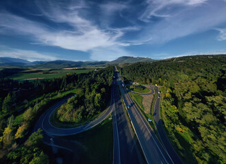 Aerial view of German highway autobahn . Drone shot of highway among forest and green field. Cars fast speed moving on freeway. A7 Kirchheim - obrazy, fototapety, plakaty