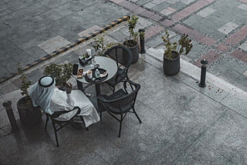 Top view of outside cafe table arabic man sitting and having coffee Jeddah Saudi Arabia