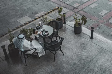 Rolgordijnen Top view of outside cafe table arabic man sitting and having coffee Jeddah Saudi Arabia © Natalia