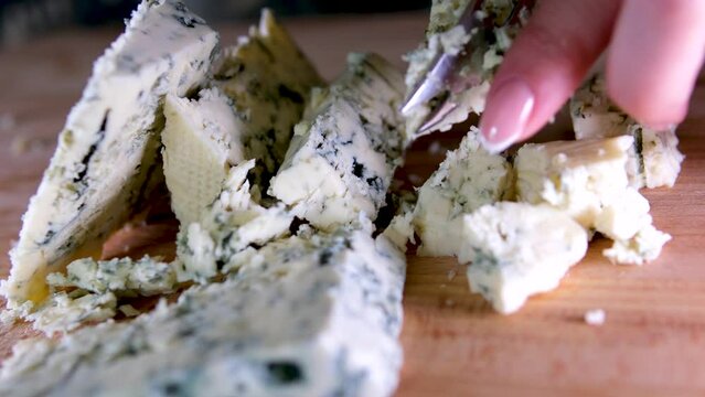 Rotation cheese on black slate plate. Delicious cheese Dorblu on the cutting board on background. High quality 4k footage