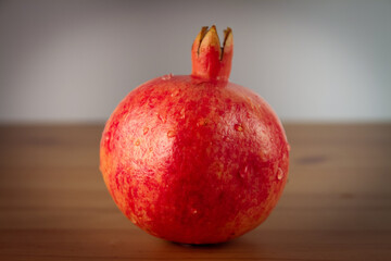 Fototapeta na wymiar Ripe pomegranate on a wooden table. Close up.