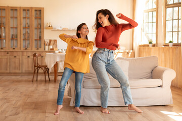 Arab Mom And Daughter Dancing Together Standing In Modern Home