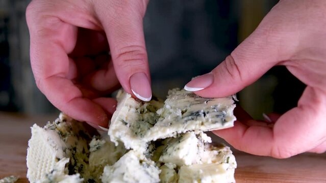 Rotation cheese on black slate plate. Delicious cheese Dorblu on the cutting board on background. High quality 4k footage