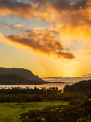 Sun slowly setting over the ocean of Hanalei Bay on the north coast of the Hawaiian island of Kauai