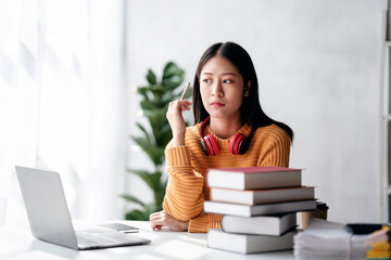 Distance education learning concept, Young woman in sweater studying education lesson online and thinking