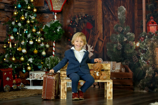 Cute Child, Holding Suitcase And Teddy Bear, Waiting At Home For Holidays