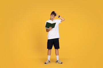 Fototapeta na wymiar Unhappy european teenager schoolboy read book, suffering from overwork and problems at school