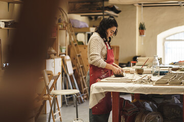 ceramist woman in her workshop working