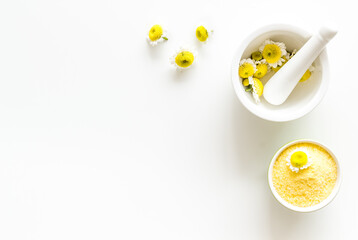 White mortar with chamomile flowers and sea salt. Herbal cosmetic beauty products