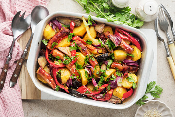Baked sausage and vegetables, peppers, zucchini, tomatoes, red onion and eggplant with sesame and cilantro served hot from oven on baking tray. Traditional lunch dish BBQ. Sausage jersey tray bake.