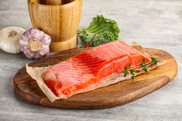 Raw salmon fillet over board