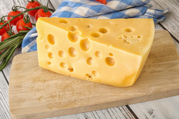Maasdam cheese piece over board