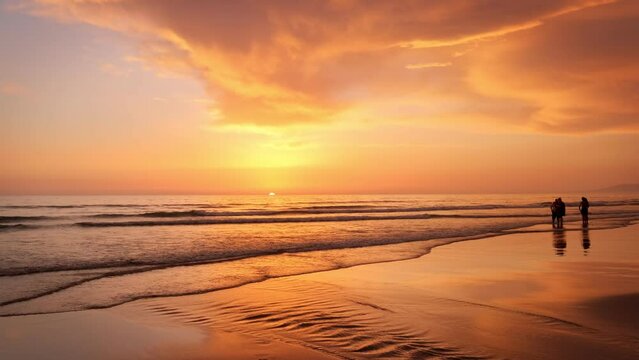 Atlantic ocean sunset with surging waves with people silhouettes at Fonte da Telha beach, Costa da Caparica, Portugal