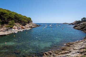 Fototapeta na wymiar Image of a pebble beach in the Costa Brava with boats in the background.